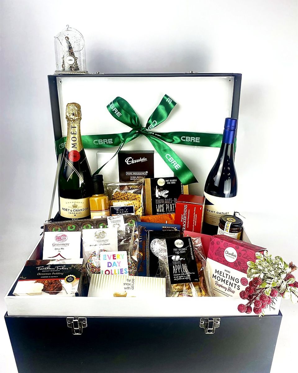 Luxury hamper trunk with Champagne, wine and gourmet treats under a branded green ribbon